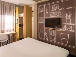 a room with a bed and a wall with drawings on it at ibis Amsterdam City West in Amsterdam