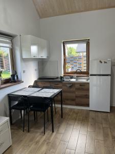 a kitchen with a table and a white refrigerator at Domek u Gołąbków Bieszczady in Lesko