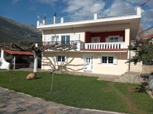 a white house with a balcony on top of it at Mytikas villa in Kandíla