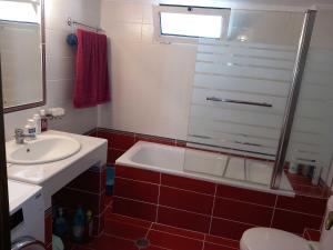a bathroom with a tub and a toilet and a sink at Mytikas villa in Kandíla