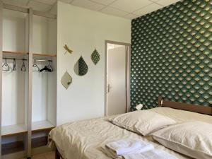 a bedroom with a bed and a green and white wall at Bastide en Margeride in Châteauneuf-de-Randon