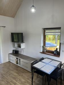 a living room with a table and a flat screen tv at Domek u Gołąbków Bieszczady in Lesko
