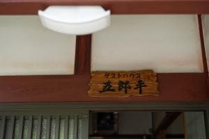 a sign on the wall above a door in a room at ゲストハウス五郎平 in Nagahama