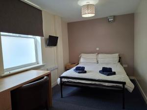 a bedroom with a bed with two towels on it at Spa Court in Cheltenham