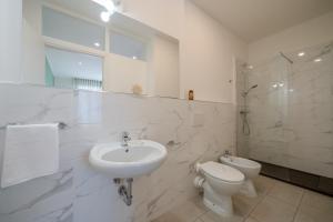 a white bathroom with a sink and a toilet at hotel La pineta in Marina di Carrara +11 photos