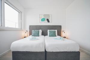 two beds sitting next to each other in a bedroom at Villa Delfina with private pool in Mariquiteira