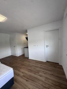 an empty room with a bed and a door at Bayman Apartments in Ellhofen