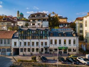 a building with cars parked in a parking lot at Tsarevets Boutique Hotel & SPA in Veliko Tŭrnovo