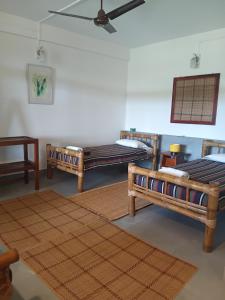 a room with three beds and a rug at Longchen Homestay in Dimapur +31 photos