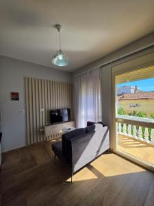 a living room with a couch and a large window at Eagle’s Nest in Shkodër