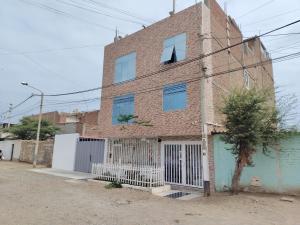 an old brick building with a white gate at Hospedaje Kaiak in Pacasmayo