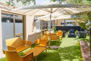 a row of chairs and tables with an umbrella at hotel La pineta in Marina di Carrara