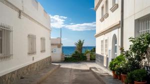 an alley between two buildings with the ocean in the background at Aguas de Mar in Castillo de BaÃ±os