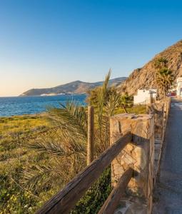 a wooden fence next to a road next to the ocean at Aguas de Mar in Castillo de BaÃ±os +10 photos