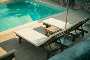 two chairs and an umbrella next to a swimming pool at Panorama View Holiday Home in Šušanj