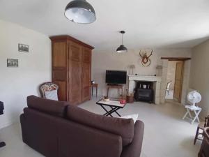 a living room with a couch and a fireplace at Le petit scevolles in Verrue