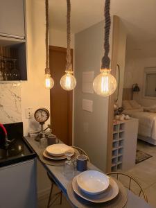 a kitchen with a table with plates and lights at Flat 701 in Guarulhos