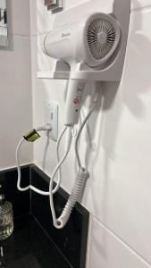 a hair dryer is attached to a wall in a bathroom at Flat 701 in Guarulhos