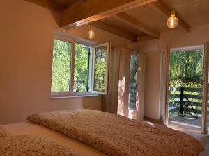 a bedroom with a large bed with windows in it at Fűzfás Apartman in Siófok