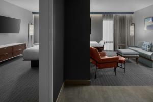 a hotel room with a bedroom and a living room at Courtyard by Marriott Woodland in Woodland +74 photos