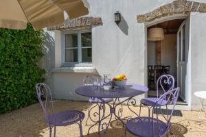 a purple table with chairs and a bowl of fruit on it at Résidence Odalys Le Château de Kéravéon in Erdeven