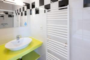 a white bathroom with a sink and a mirror at Résidence Odalys Le Château de Kéravéon in Erdeven +66 photos