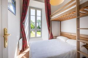 a bedroom with a bunk bed and a window at Résidence Odalys Le Château de Kéravéon in Erdeven