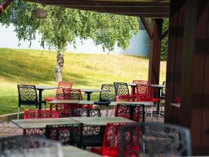 a group of tables and chairs sitting under a tree at ibis Caen Porte De Bretagne in Bretteville-sur-Odon