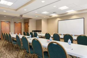 a conference room with tables and chairs and a whiteboard at University Hotel Davis Area by IHG in Dixon