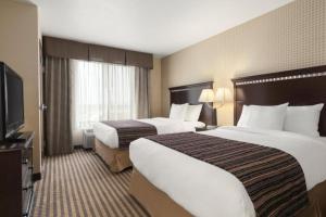 a hotel room with two beds and a flat screen tv at University Hotel Davis Area by IHG in Dixon +28 photos