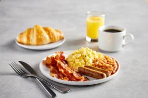 a plate of breakfast food with eggs bacon and toast at University Hotel Davis Area by IHG in Dixon