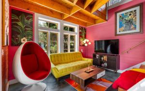 a living room with a yellow couch and a red chair at Tickle Me Tides in Inlet Beach