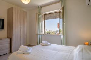 a bedroom with a white bed and a window at hotel La pineta in Marina di Carrara