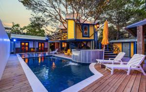 a home with a swimming pool and a house at Tickle Me Tides in Inlet Beach