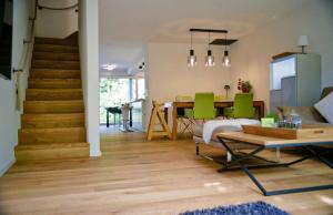 a living room with a table and green chairs at City Lake & Peaks Thun in Thun