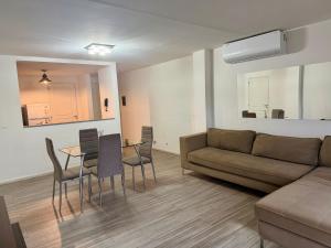 a living room with a couch and a table and chairs at Puerto Amarras Apartment in Santa Fe