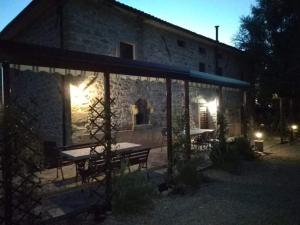 a building with a table and benches in front of it at Raggio Campacci di Sacchetti Vanessa in Rovereti