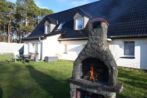 a stone fireplace in the yard of a house at FEWO RENKEN in Trassenheide