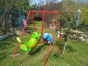 a swing set in a yard with two toys at Raggio Campacci di Sacchetti Vanessa in Rovereti