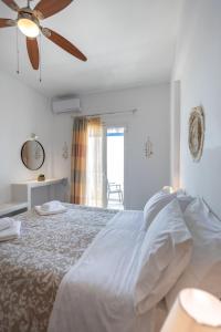 ein Schlafzimmer mit einem Bett und einem Deckenventilator in der Unterkunft Marisini Sea View in Batsi