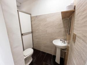 a small bathroom with a toilet and a sink at La Casita Rooms - Habitaciones Coveñas in Coveñas