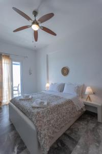 ein Schlafzimmer mit einem Bett und einem Deckenventilator in der Unterkunft Marisini Sea View in Batsi