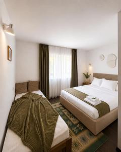 a hotel room with two beds and a window at POARTA PADINA, statiunea Pestera-Padina, Bucegi in Moroeni