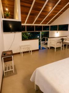 a room with a bed and a tv on the wall at Lagoon Village B&B y SPA in Tarapoto