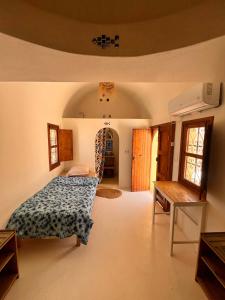 a bedroom with a bed and a staircase in it at Dar Hallouma - WostelDjerba community in Djerba