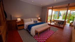 a bedroom with a bed and a large window at Viscas Hotel Luxury Resort & Spa in Pariahuanca