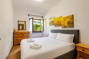 a bedroom with a large white bed and a window at Eldann Apartment - Tradizione e Relax a Sappada in Sappada