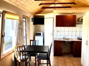 a kitchen with a black table and chairs in a room at Dom Wczasowy u Marci in Tymień