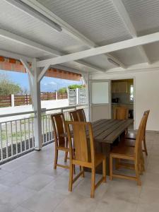 a dining room with a wooden table and chairs at Gites vallée des caraibes in Bouillante