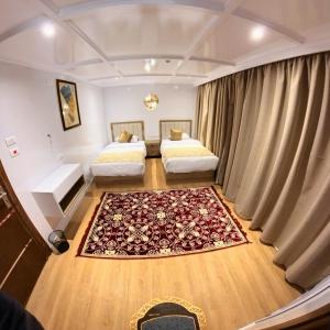 a hotel room with two beds and a rug at The Nile Dahabiya Lodge in Luxor